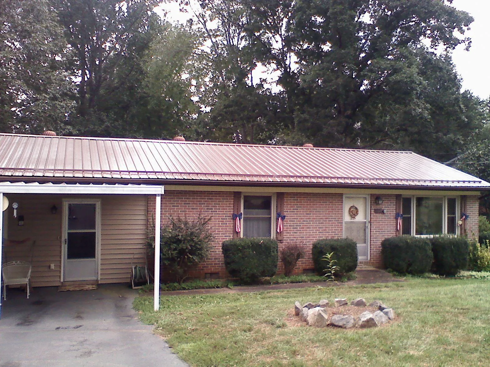 Bronze metal roof and carport on a brick ranch home — Roof Repair work by our crew in Burleson