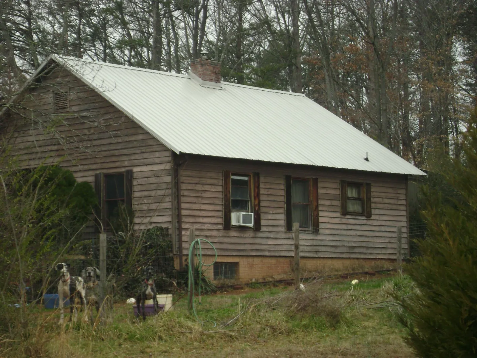 White metal roof on an old wood sided farmhouse, from a Metal Roof Installation job in Burleson